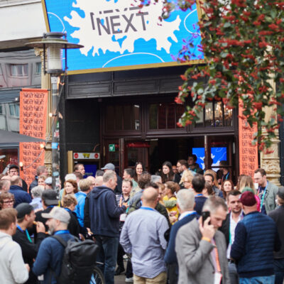 Das Theater Schmidts Tivoli während der NEXT Conference. Vor dem Theater stehen viele Menschen, viele miteinander im angeregten Austausch.