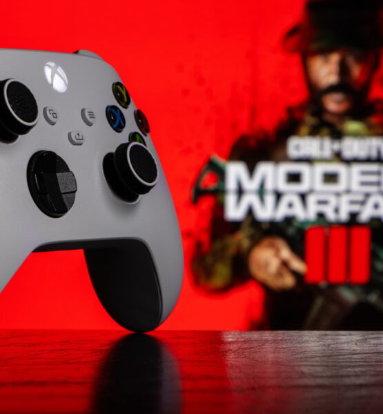 Ein Xbox Series Controller auf dem Tisch, im Hintergrund sieht man etwas verschwommen das Logo von Call of Duty: Modern Warfare 3.